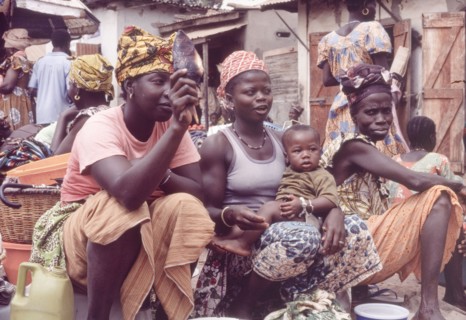 Female traders at Banjul market. Female traders sell food produce at a bustling outdoor market in
