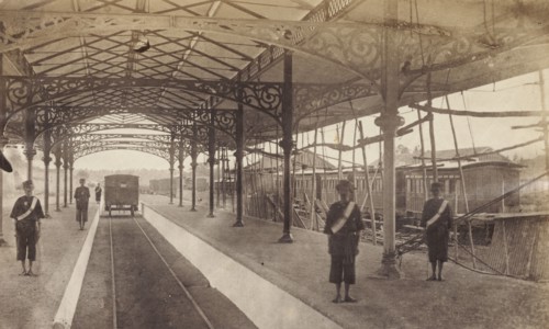 Colombo railway station. Station attendants stand on the platform as a train departs from Colombo