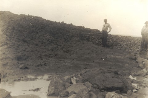 The highest point on the island of Trinidad. Two figures stands on a rocky incline at the highest