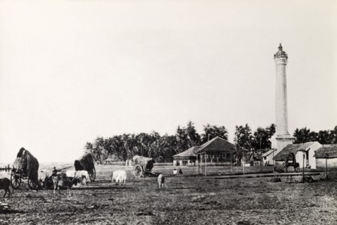 A rural landscape in Burma (Myanmar). A tall pillar-like structure, possibly a lighthouse,