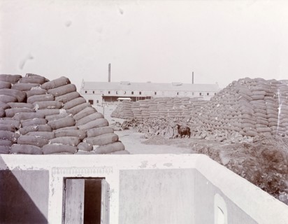 Sacks of cotton outside a factory in India. Sacks of cotton are piled high in a yard outside a