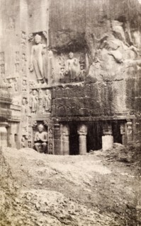 An entrance to the Ajanta caves. Religious figures are carved into the rockface outside a pillared