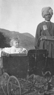 Indian servant with a British toddler. A turbaned Indian servant watches over a British toddler who