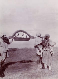 Palanquin for a baby. A group of Indian servants carry a miniature, tasselled palanquin for a baby,