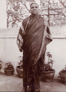 Portrait of an Indian man. An Indian man in traditional, possibly religious robes, poses outdoors