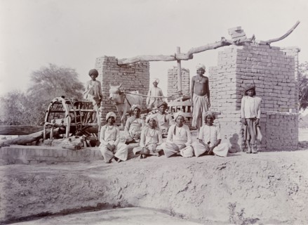 A bullock-driven water wheel, India. A group of Indian labourers pose for an outdoor portrait