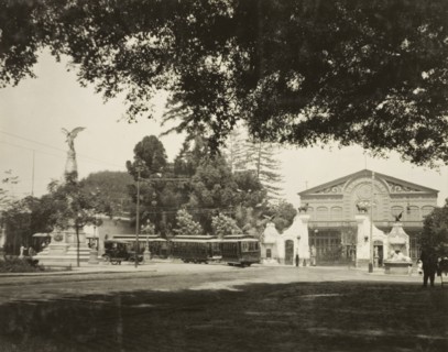 A street tram in Lima. A tram travels around the corner of a street in Lima, past a grand,