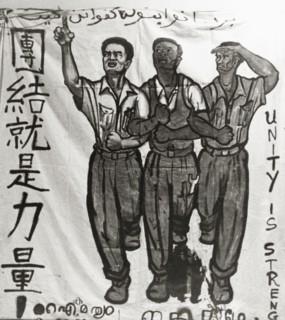Unity is Strength'. A hand-painted banner campaigns for unity during the Singaporean Merdeka