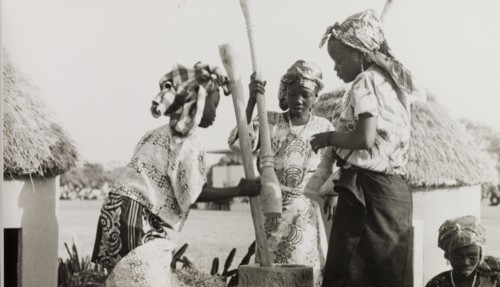Nigerian girls using pestles and a mortar. Three young women from Kaduna Children's Village use