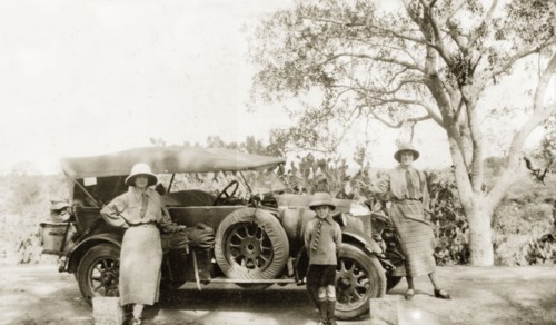 Preparing to embark on a journey. Two European women and a young boy pose beside a convertible car