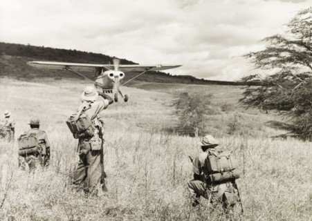 Kenya Police Airwing. Four officers of the Kenya Police Airwing watch as a light aircraft comes in