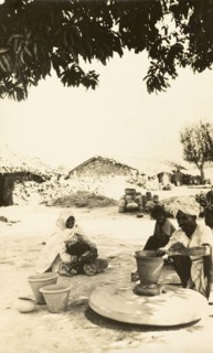 Indian craftsman at a potter's wheel. A craftsman sits beneath a shady tree as he sculpts a clay