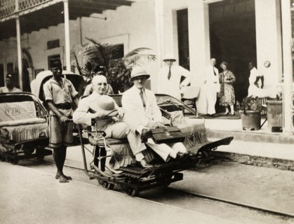 A rail trolley at Beira station. Two European men ride a narrow gauge rail trolley at Beira railway