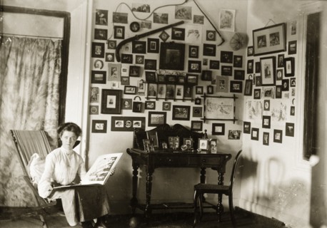 In the drawing room at Penshew House. A European woman browses through a photograph album in the