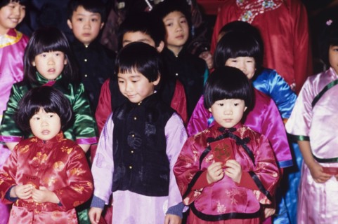 Children celebrating the Chinese New Year. Young children wear traditional Chinese dress during