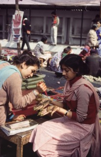 Applying henna for Diwali celebrations. A young woman has the palm of her hands decorated with