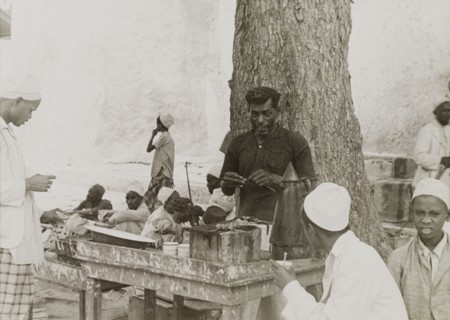 Snack food in Lamu. A street trader grills snack food in Lamu's main square. Lamu, Kenya, circa