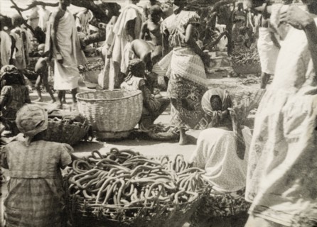 Pretzel stalls at a Ghanaian market. Female traders sell baskets full of pretzels at a busy market