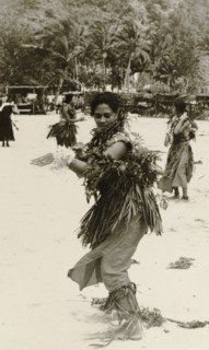 A Fijian dancer. A Fijian woman performs a traditional dance on a beach, dressed in ceremonial
