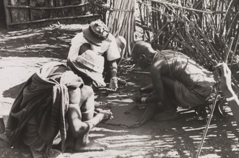 Kikuyu men reading their fortune. A group of Kikuyu men gather around to read their fortunes by