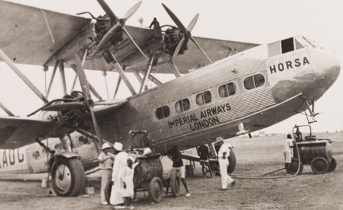 Refueling an Imperial Airways biplane, Kenya. Ground crew refuel an Imperial Airways long-range
