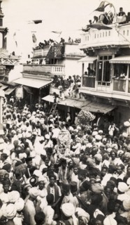 Street festival in Secunderabad. Crowds of people carry religious icons decorated with garlands as