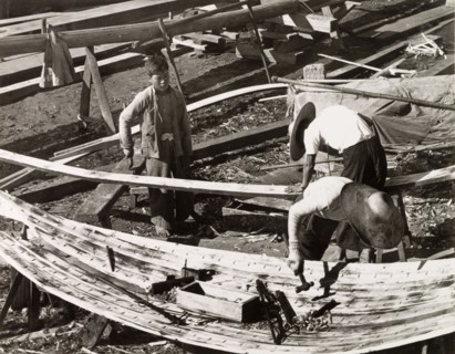 Constructing a sampan. Two men build a sampan at a boatyard in Aberdeen Harbour, whilst a third