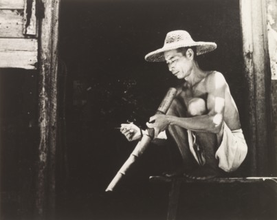 Smoking a bamboo pipe. A Chinese worker enjoys his bamboo pipe during a smoking break. Hong Kong,