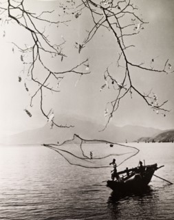 Fishing in a Hong Kong bay. A fisherman casts his net into the tranquil waters of a Hong Kong bay.