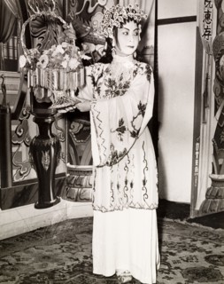 Portrait of a Chinese actress. An actress from a Chinese opera poses with a basket of flowers,
