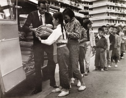 Children queuing for food, Hong Kong. City children queue outside a resettlement block in Kowloon,