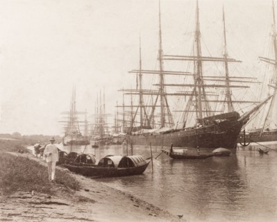Vessels moored on the Hooghly River. Small boats beached on the sandy banks of the Hooghly River