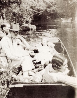Punting during May Week, Cambridge. A group of friends relax in a punt on the banks of the River