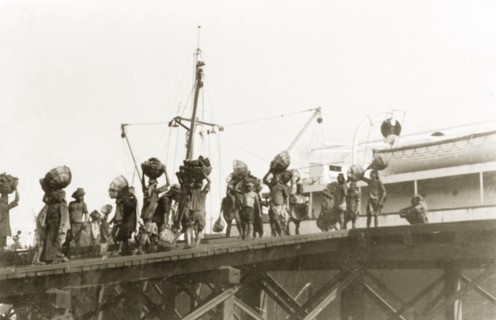 Coaling, the old fashioned way'. Indian porters refuel a ship with coal at Calcutta docks. Calcutta