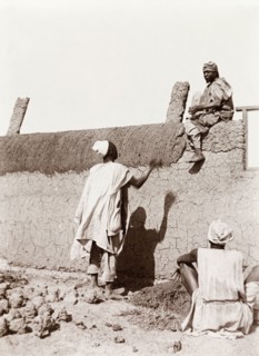Construction of a new school in Kano. Nigerian builders put the finishing touches to a mud wall