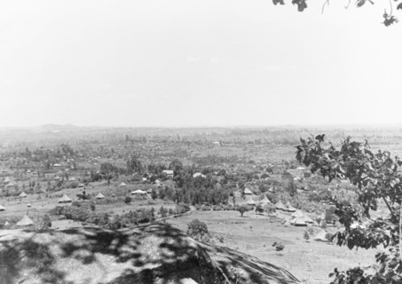 The Kano plains at South Kavirondo. Thatched huts with conical roofs are dotted amongst scrubland