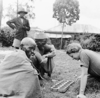 Elspeth Huxley plays a mancala game. Elspeth Huxley contemplates her next move as she plays a