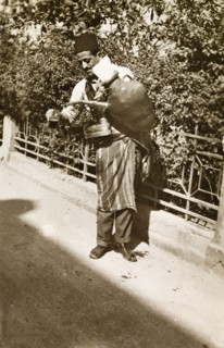 Lemonade seller, Palestine. A lemonade seller pours out a drink from a large jug strapped to his