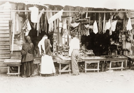 Stall at a 'shuk', Palestine. Shoppers browse a variety of items for sale on a stall at a 'shuk'