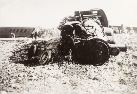 Derailed steam locomotive at Ras el Ain. A steam locomotive lies in pieces on a railway embankment,