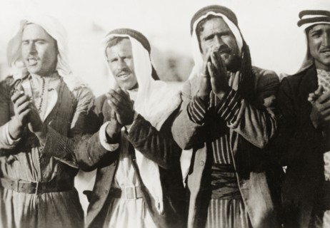 Pilgrims at a Nebi Musa procession. Four Arab men clap their hands together as they take part in a