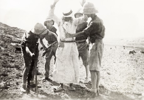 British soldiers searching a Palestinian Arab. Four British soldiers perform a body search on a