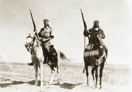 Desert police on patrol. Two mounted Arab police officers patrol the desert with rifles during the