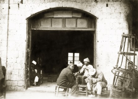 A Palestinian cafe. A group of Arab men socialise in the doorway of a cafe. British Mandate of