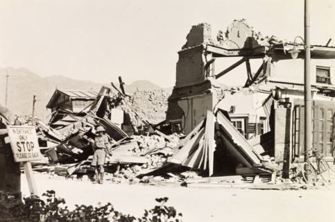 Earthquake damage in Quetta, 1935. A European man stands in the debris of a ruined building,