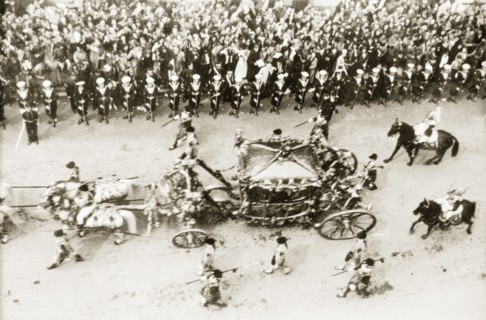 The royal carriage at George VI's coronation procession. Crowds of spectators line Whitehall to