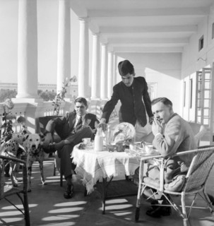 Tea on the veranda, India. Two European men take tea and breakfast on the pillared veranda of a