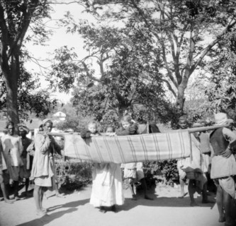 Children travelling in a sedan chair. An Indian ayah (nursemaid) watches over two European children