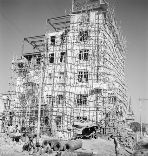 Construction of a six-storey building, Calcutta. A partially completed building is encased with