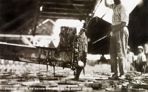 Asphalt manufacturing plant. A factory worker pours liquid asphalt taken from the Pitch Lake at La